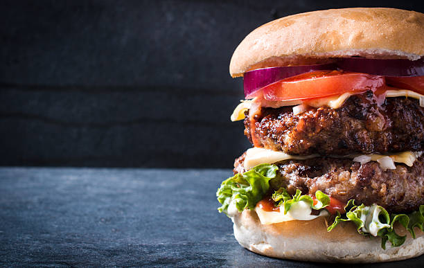 Close up of heavily garnished beef burger