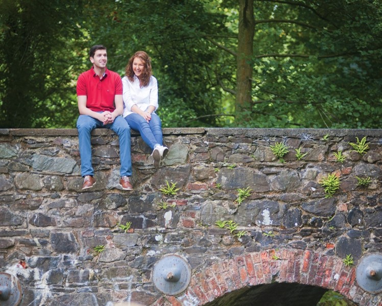 Man and woman sitting on stone wall