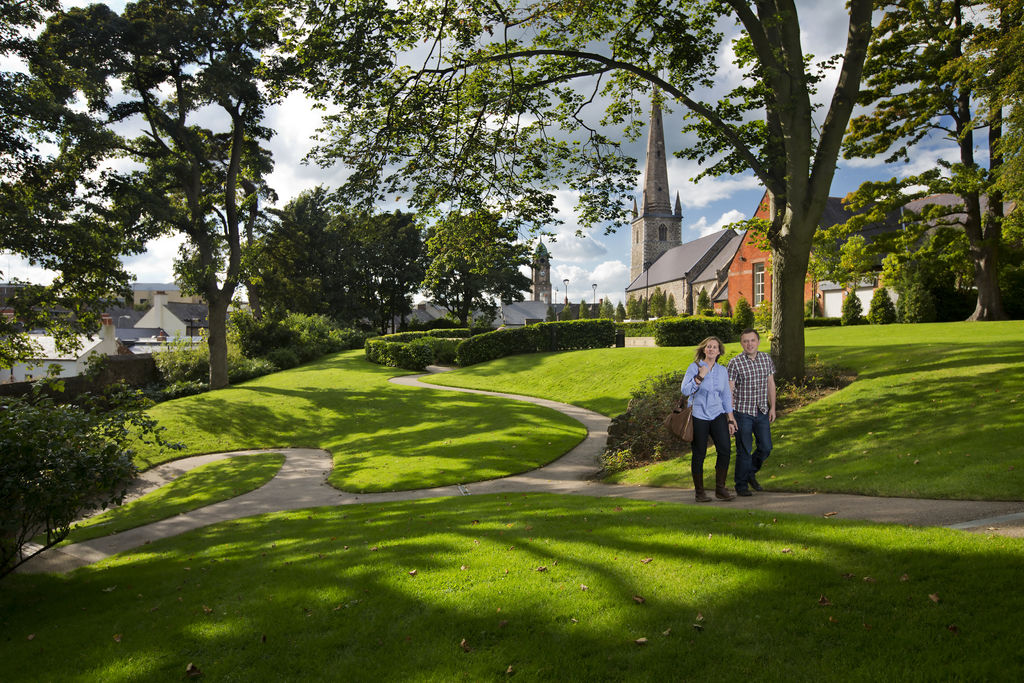 Man and woman walking in lush green park